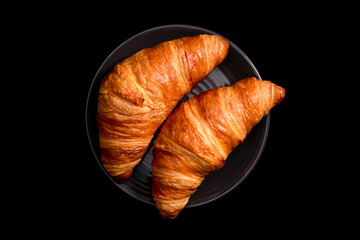 Fresh croissants on a black background. Top view.