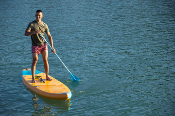 Man on sub board floating on ocean sea.
