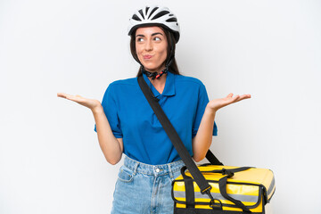 Young caucasian woman with thermal backpack isolated on white background having doubts while raising hands