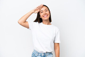 Young caucasian woman isolated on white background saluting with hand with happy expression