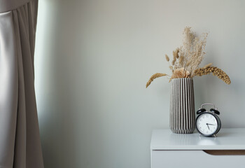 bedside table with vase and clock