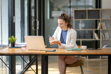 Businesswoman sitting in front of laptop considering work in the office Think about the work concept. Plan a new project