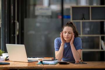 Businesswoman sitting in the office is stressed, working hard, feeling stressed and dizzy from...
