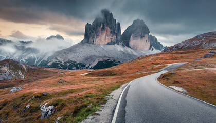 dramatic morning view of national park tre cime di lavaredo with asphalt road gloomy autumn landscape in dolomite alps south tyrol location auronzo italy europe traveling concept background - obrazy, fototapety, plakaty