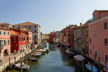 Fototapeta na wymiar Chioggia town in venetian lagoon, water canal and boats. Veneto, Italy, Europe