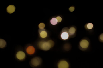 festive New Year's bokeh of warm yellow color, blurred on a dark background