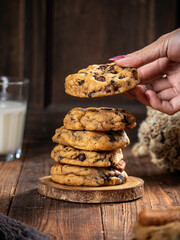 Cookies are stacked neatly on a wooden placemat, isolated with a wooden table background.