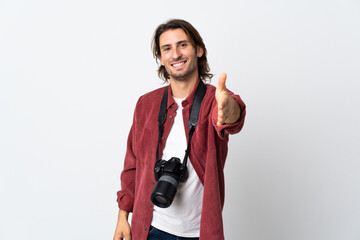 Young photographer man isolated on white background shaking hands for closing a good deal
