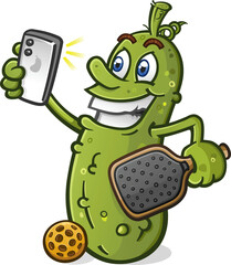 Naklejka premium Smiling pickle cartoon character taking a selfie photo with a smart phone and holding a pickleball paddle and gear