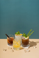 Composition with alcoholic cocktails on podium with ice on colored background.