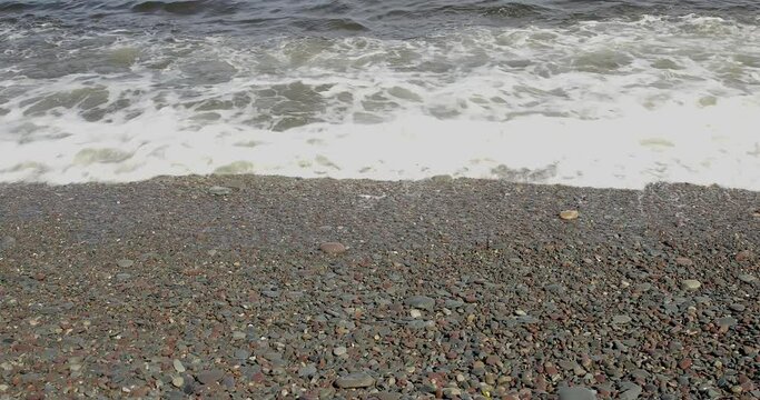 Waves crashing on a rocky beach along the road 8100 to Hamningberg in summer, Varanger Peninsula, Norway.