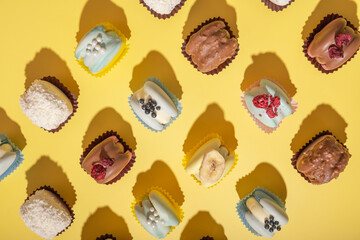 Set of different macaroons on yellow background top view, flat lay