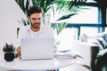 prosperous young man checking news on exchange website