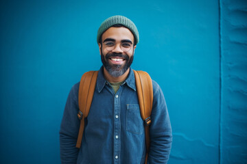 Portrait of a Happy Man Standing In Front of a Blue Wall