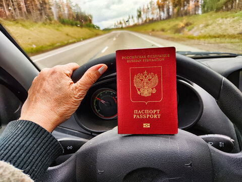 Russian passport in hand of driver woman. Russian cars banned for entering in Europe. Russian tourism closed during war of Russia and Uk. Confiscation of Russian car and sanctions against Russian