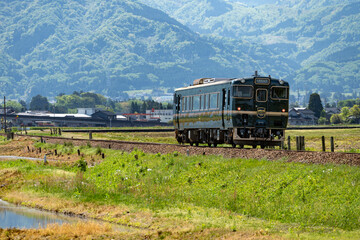 Obraz premium 田園地帯を走る城端線の観光列車・ベル・モンターニュ・エ・メール