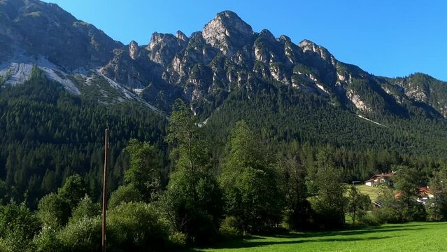 Mountains in Austria at the Brenner Pass at dusk with meadows and forests in 4k