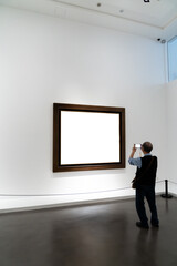 Fototapeta premium Audiences looking at oil paintings in gallery
