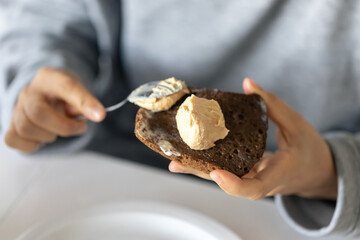 Woman spreading bread, close up, breakfast concept.