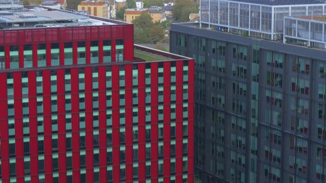 Upward establishing shot in East Croydon of shaded multi storey buildings, tilting up northwards to a sunlit view of mainly suburban housing in the distance. London, England, UK.