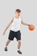 Teenage boy playing basketball