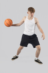 Teenage boy playing basketball