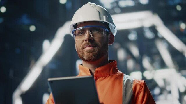 Satisfied factory inspector working tablet standing at production close up. 