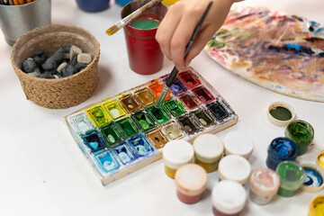 close up shot of artist puts a brush in watercolor paint