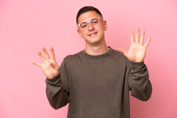 Young Brazilian man isolated on pink background counting nine with fingers