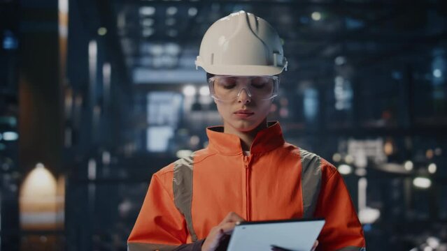 Tablet supervisor checking factory manufacturing facility making notes close up.