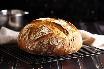 Selbstklebende Fototapeten fresh homemade bread on a cooling rack © studioworkstock