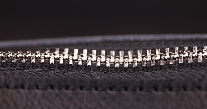 metal zipper on a black leather product, zipper on a black women's handbag close-up