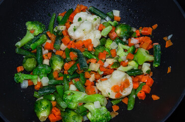 Fresh vegetables fried in a frying pan