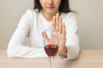 Alcoholism, depressed asian young woman hand refuse red wine or alcoholic beverage, female drinking...