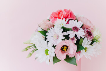 Beautiful bouquet of pink and white flowers on a pink pastel background.
