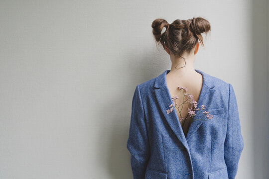 Teenage girl wearing blue blazer backwards with flowers on her back