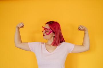 Woman wearing heart shaped sunglasses flexing muscles
