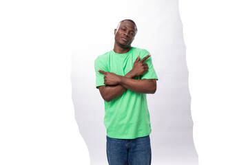 american brunette man with short haircut dressed in a light green t-shirt points his hand to the side advertising space