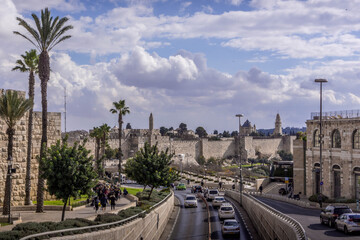 The road traffic on Jerusalem highway going along the walls of the Old town, with the palm trees,...