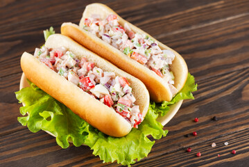 Chopped Italian sandwich in hot dog buns with lettuce leaves in a plate.