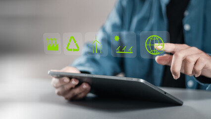 Businessman using tablet with reduce CO2 emissions carbon global symbol on green background for climate change to limit global warming and sustainable development and green business concept. - obrazy, fototapety, plakaty