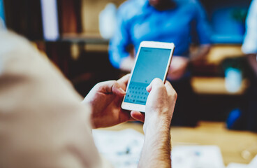  business person using mobile phone while office colleagues on standing background