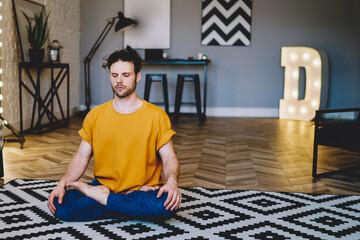 Concentrated young man with closed eyes enjoying harmony