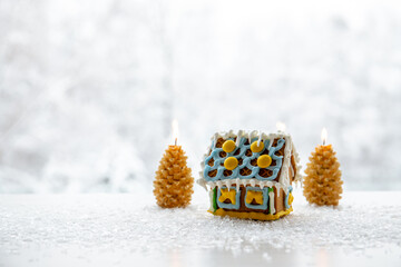 Spruce tree shape candles burning on white snowy background with winter landscape with cute...