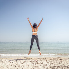 Fitness Girl jumping on the beach