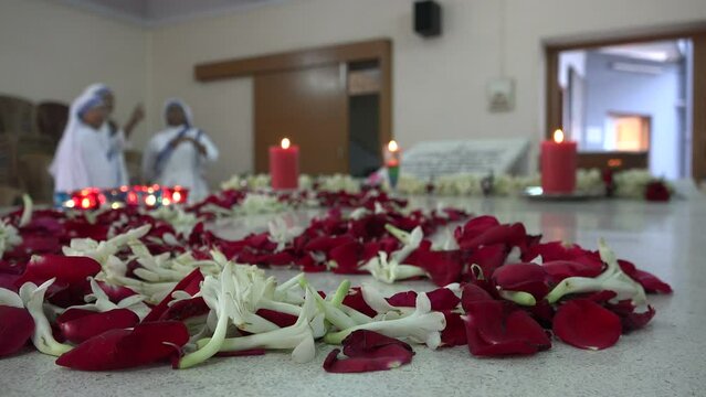 Flowers on the grave of Mother Teresa in Kolkata. Three nuns can be seen in the background. Religion in India.
