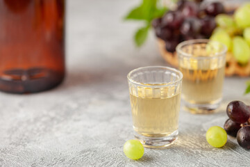 Traditional Georgian  chacha, also known as grape vodka or Georgian grappa in shot glasses  and fresh grapes