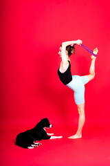 Shot of a sport female in leggings with a border collie dog isolated on yellow and red background