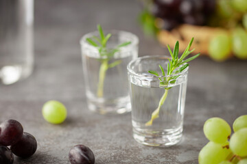 Traditional Georgian  chacha, also known as grape vodka or Georgian grappa in shot glasses  and fresh grapes