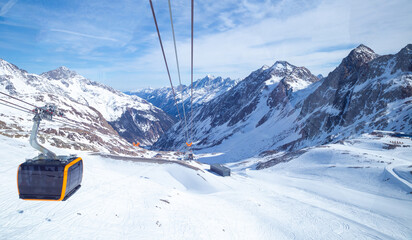 panoramic view of Alps mountain snowy range with skiing trails and cable car in Stubai Glacier,...